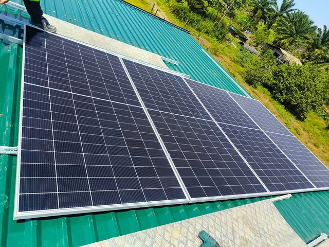 Cuatro paneles solares instalados sobre techo metálico verde en Bariloche, Meta
