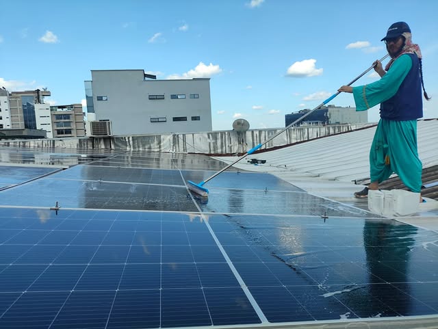 Operario limpiando paneles solares en una cubierta en Villavicencio, Meta
